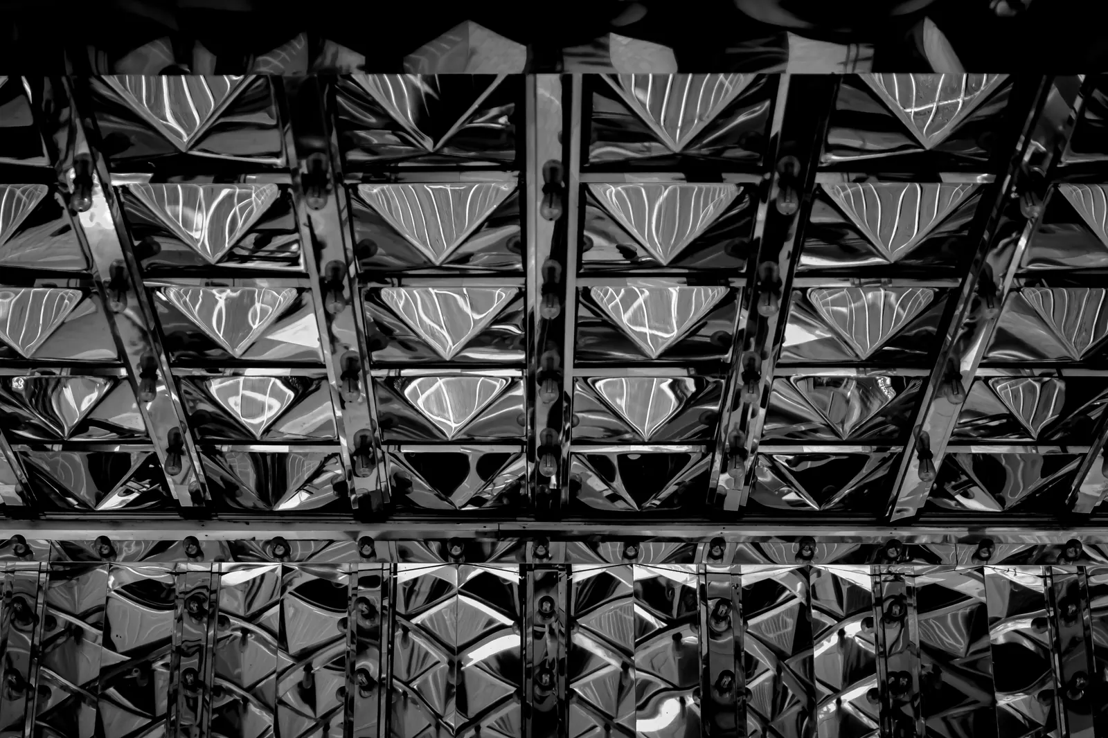 Reflective metal panels create a dense pattern of triangles in black and white.