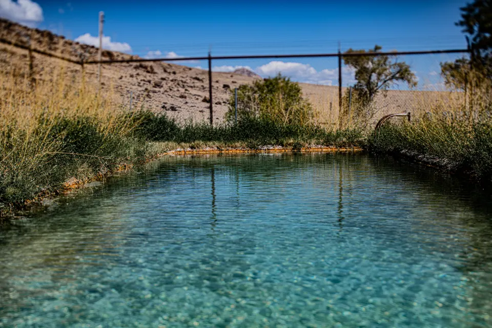 Clear blue water gathers inside the weathered walls of an open-air pool.
