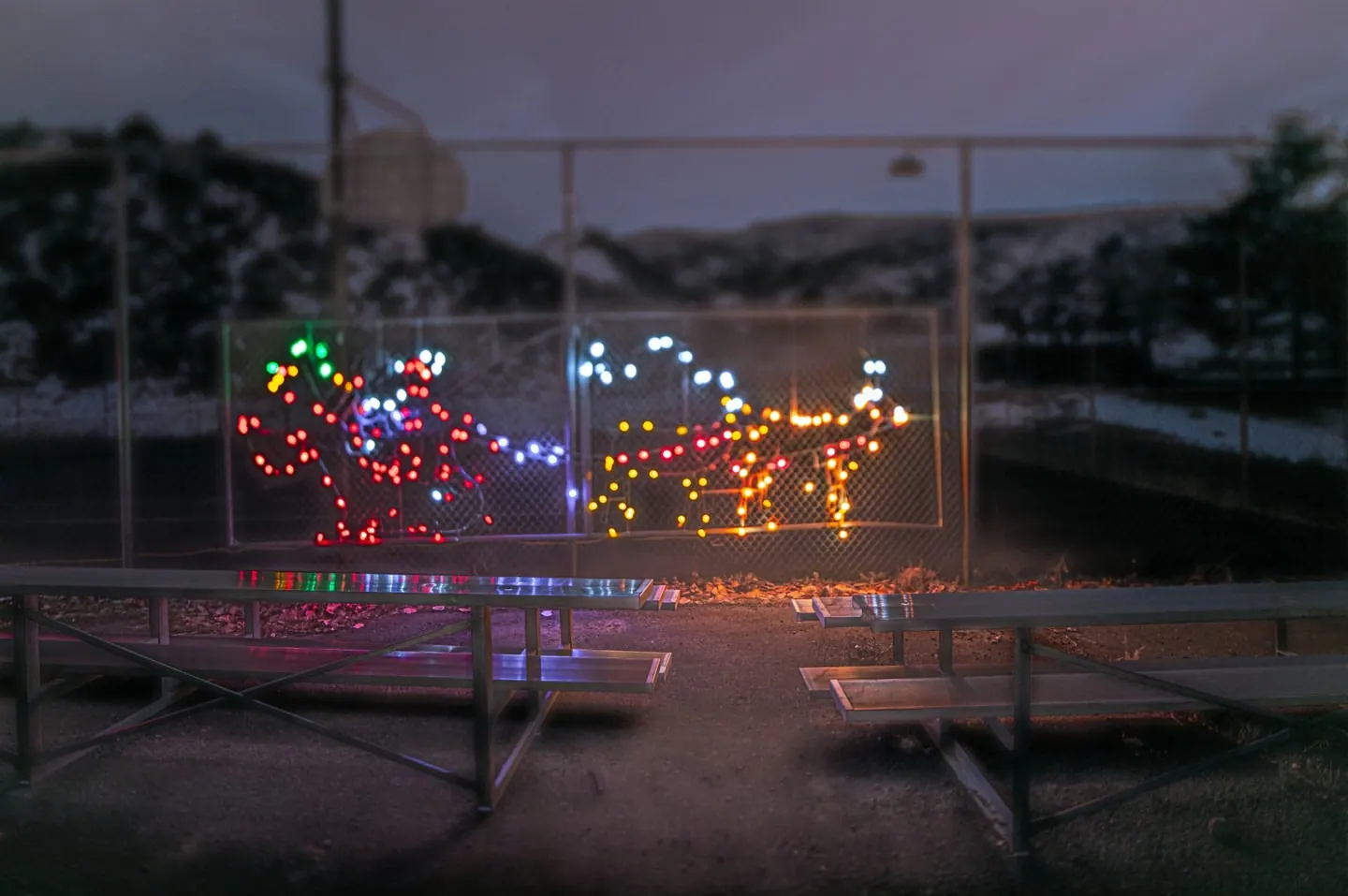 Coloured lights outline small shapes within a rectangular frame after dark.