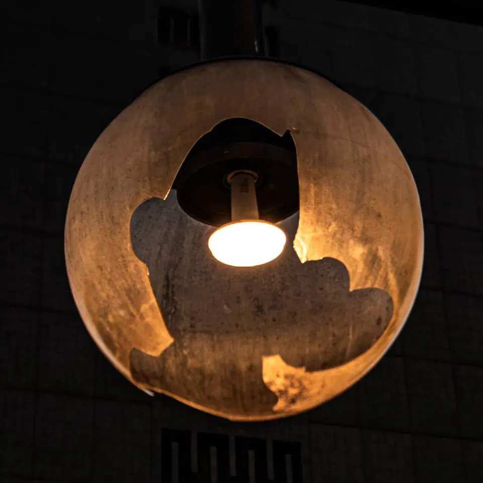A small light shines from the centre of a round metal fixture.