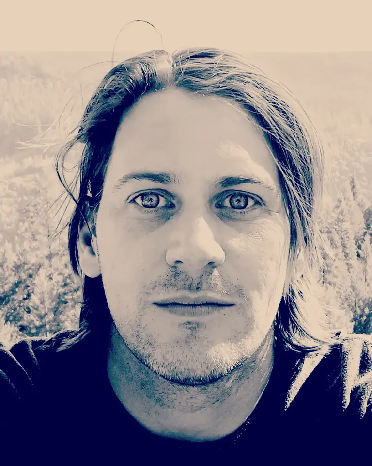 A close portrait of a person with long hair is rendered in pale blue tones.