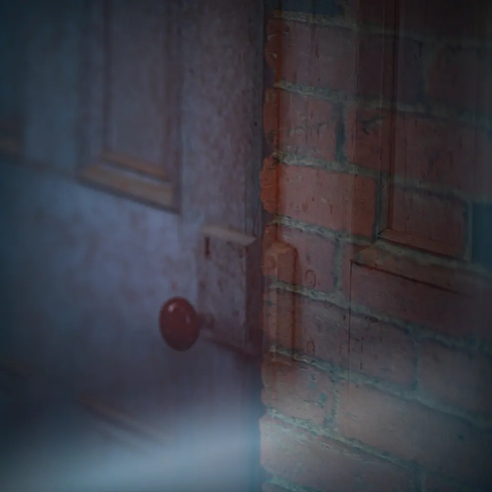 A small red handle interrupts blue glass and a softly blurred brick wall.