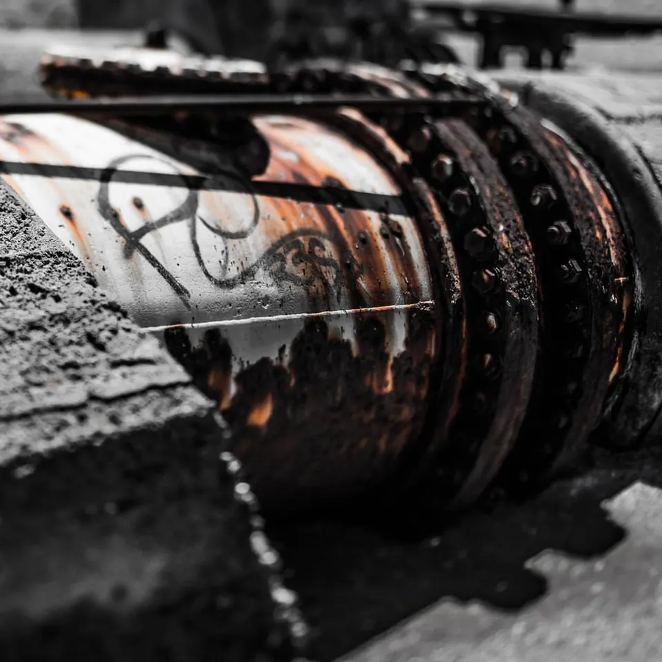 Rust, peeling paint and dark bolts mark a heavy piece of metal machinery.