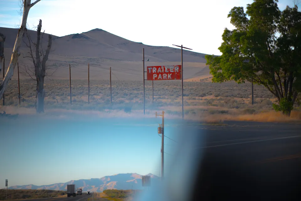 A faded roadside sign appears beyond a softly blurred blue foreground.