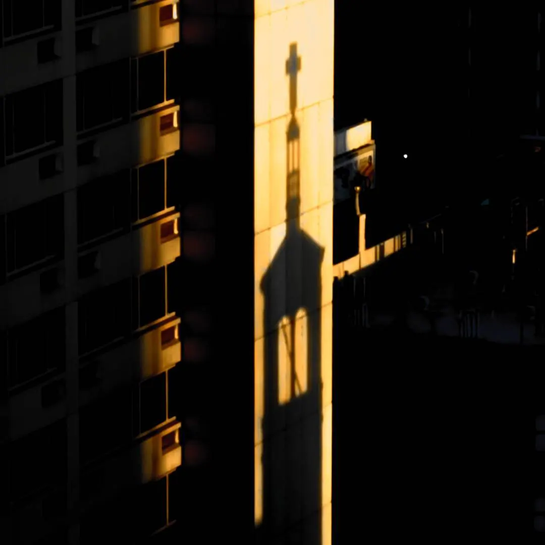 A narrow band of golden light divides a dark building facade.