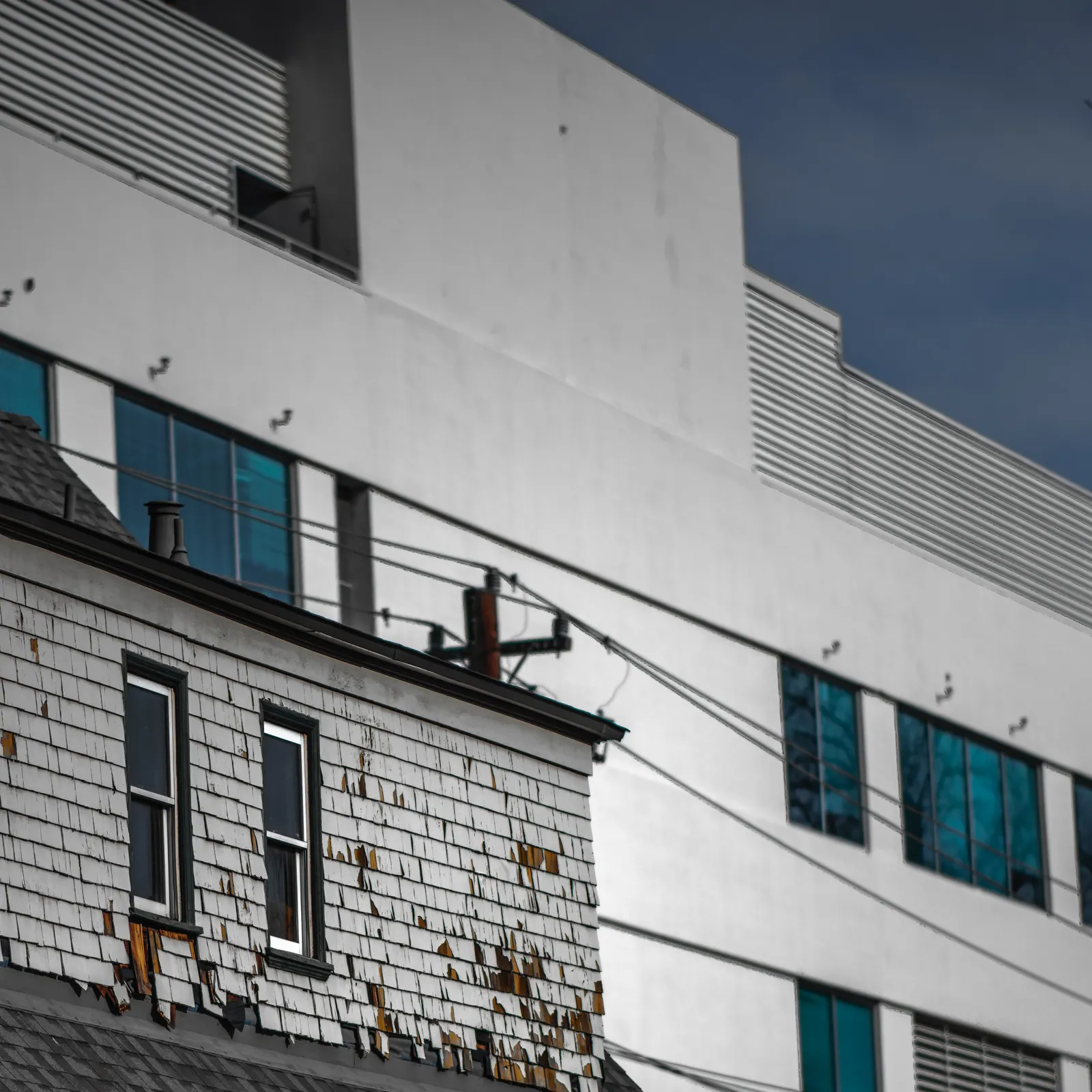 A strip of blue windows crosses the pale geometric facade of a city building.
