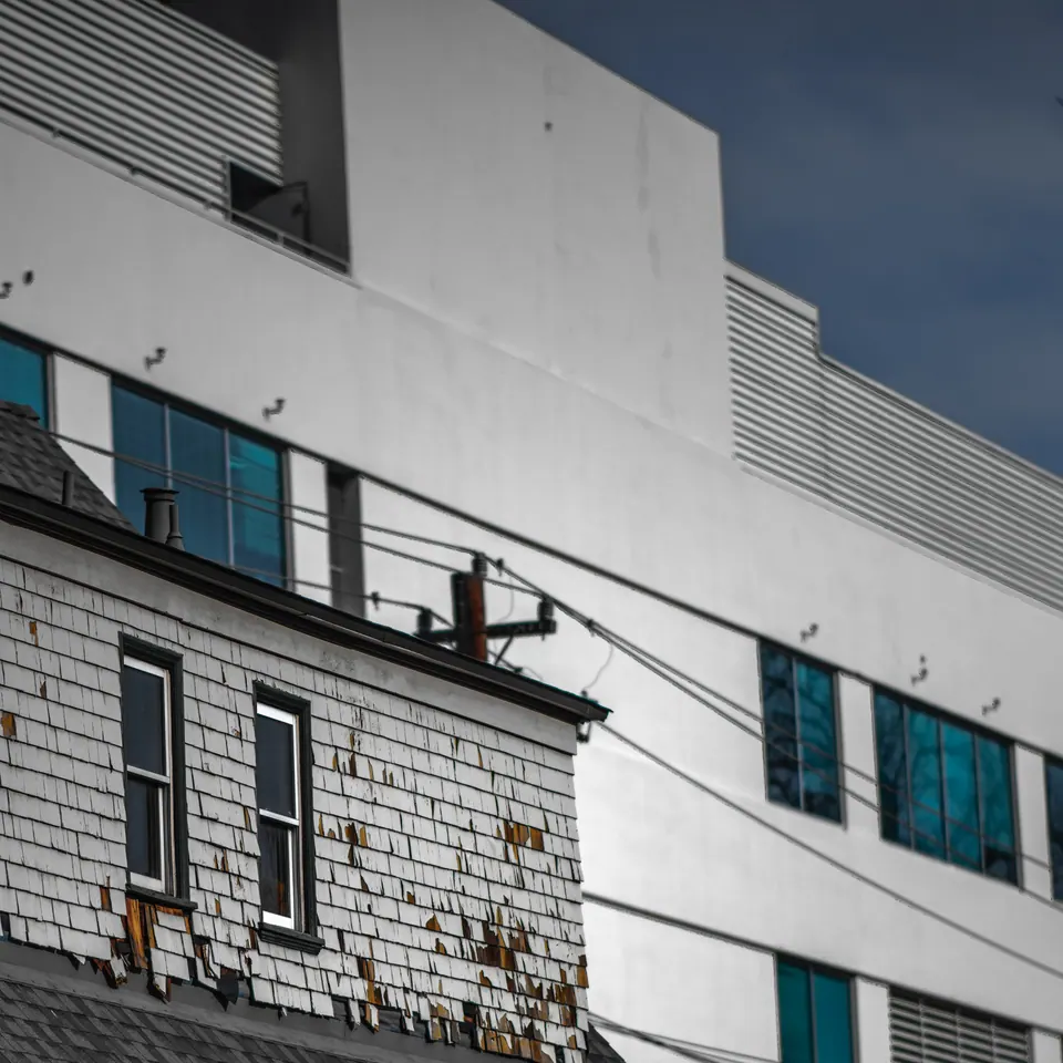 A strip of blue windows crosses the pale geometric facade of a city building.