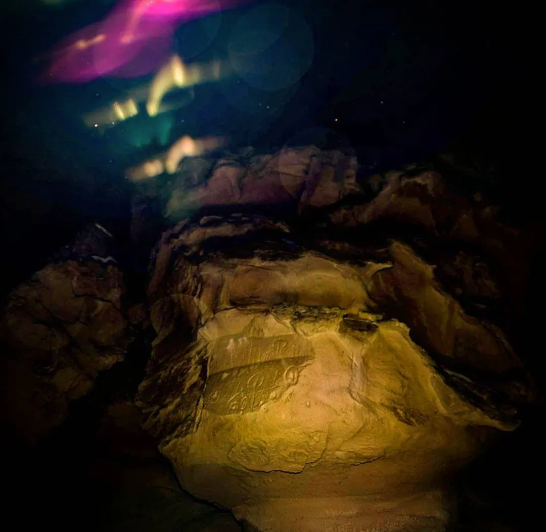 Blue, yellow and violet light moves across a dark rocky surface.