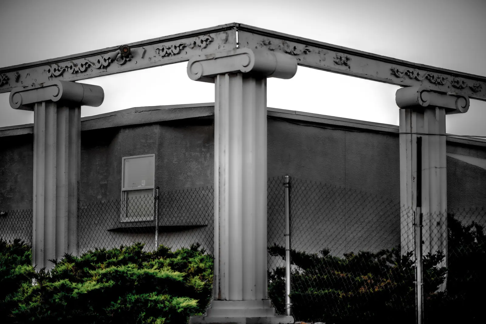 Pale decorative columns frame the corner of a quiet building.