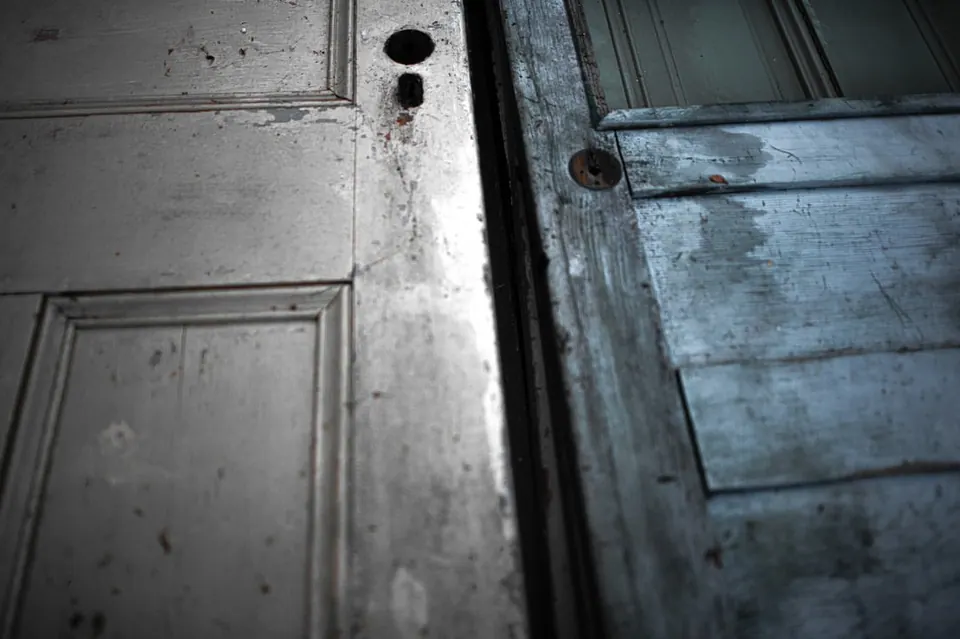 Worn panels and a keyhole mark a pair of pale blue and white doors.