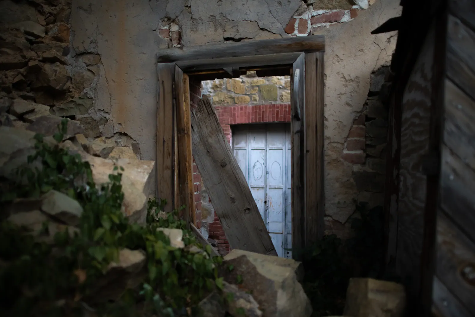 Weathered doorframes line up through the crumbling rooms of an abandoned building.