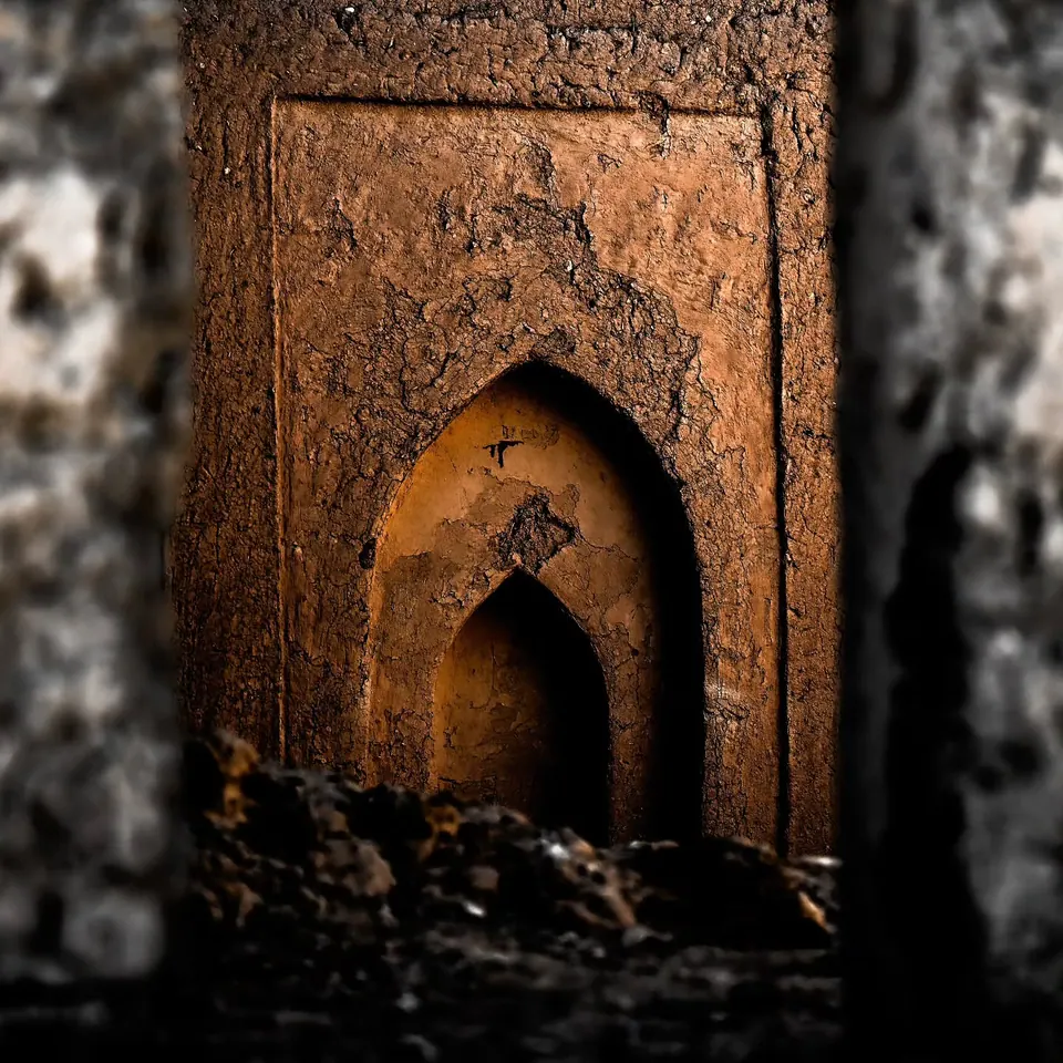 A pointed doorway opens into the dark interior of an earthen building.