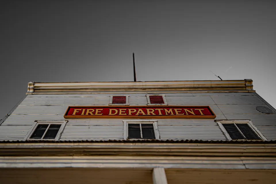 Red lettering sits above the windows of a white fire-department building.