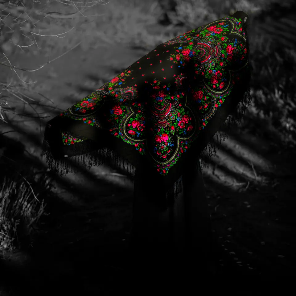 Red and green floral patterns stand out against dark, softly blurred surroundings.