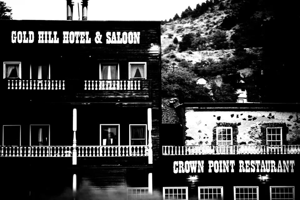 Bold white hotel and saloon signs stand out against dark timber in black and white.