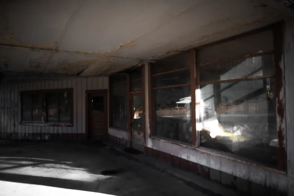 Sunlight falls through old windows onto the floor of an abandoned room.