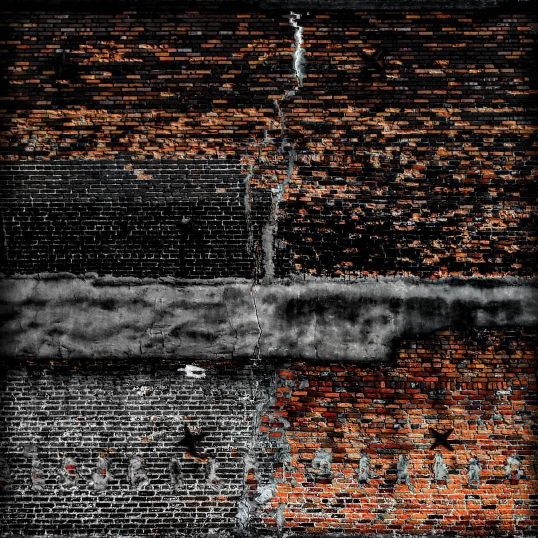 Warm brickwork rises above a dark, weathered wall.