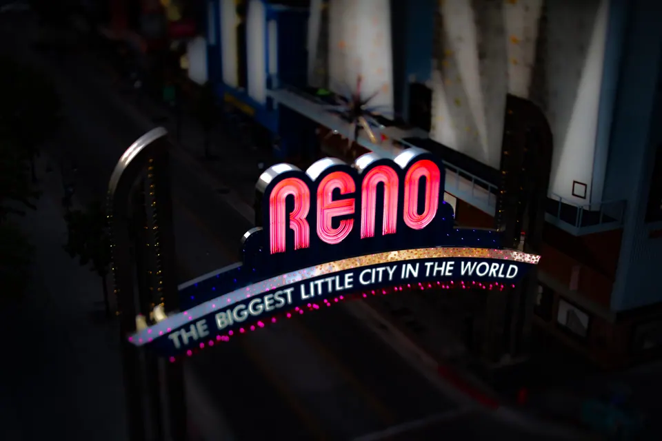 The illuminated Reno arch glows red and white against the dark city around it.