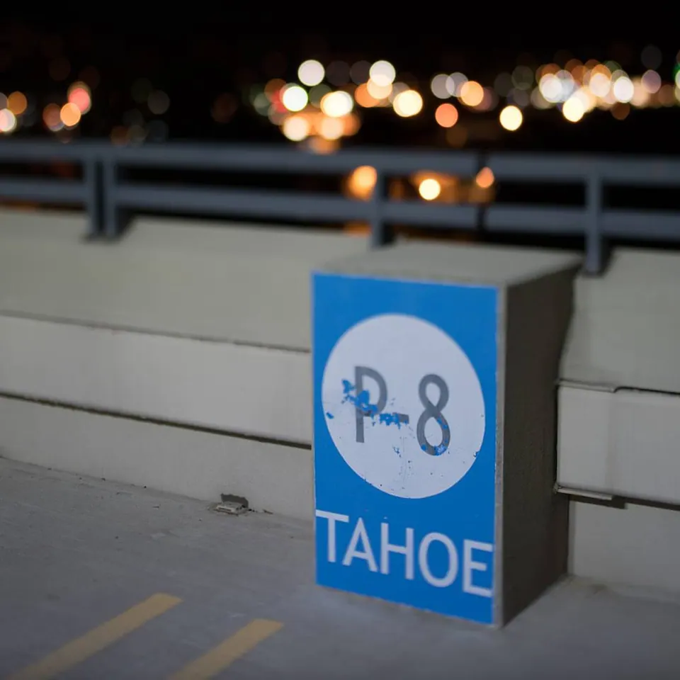 A blue Tahoe sign stands beside pale railings and distant blurred lights.