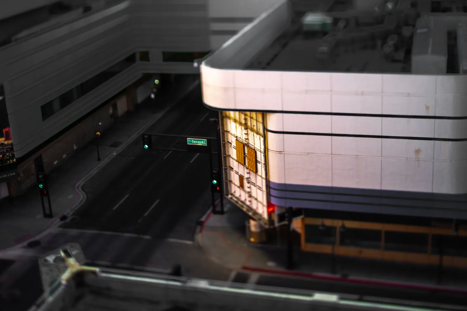 A rounded building facade catches light beside a dark street below.