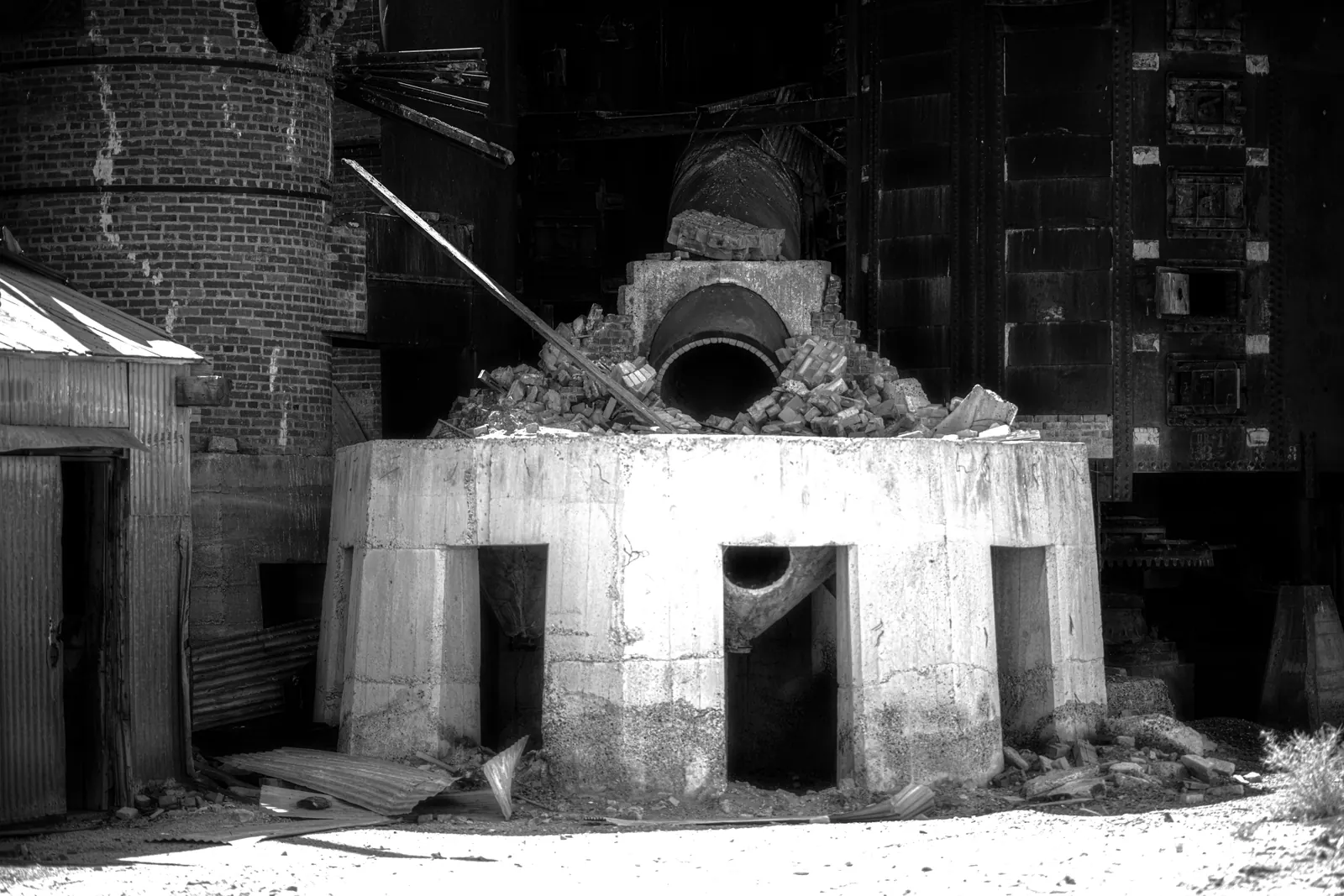 A large circular industrial structure occupies a shadowed brick interior.