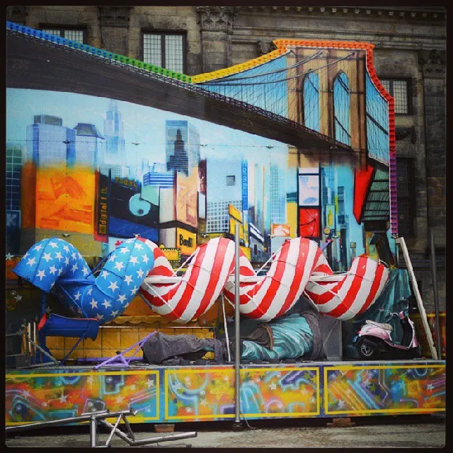 Bright stripes and a painted mural cover an empty fairground attraction.
