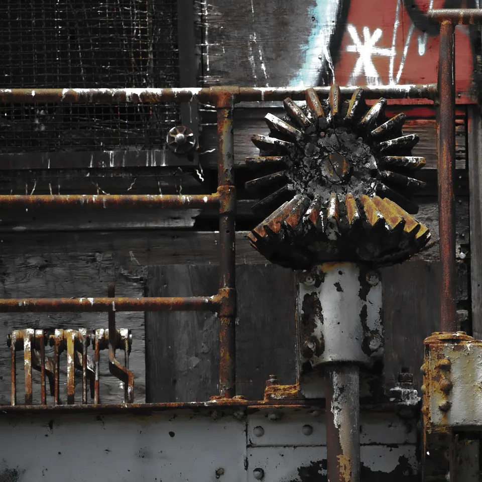 An ornate metal fitting catches a little light against a weathered industrial surface.