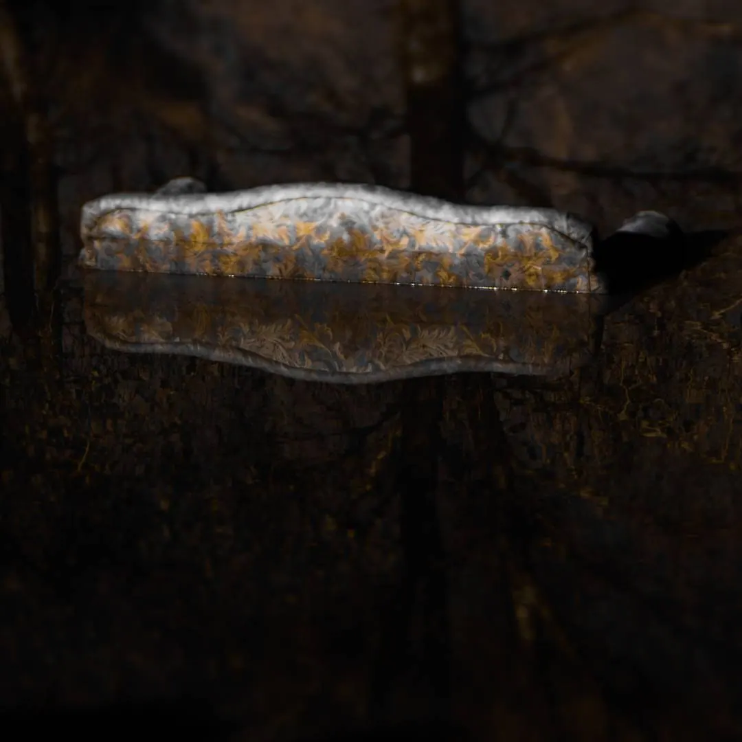 A weathered glass bottle lies against a dark, textured background.