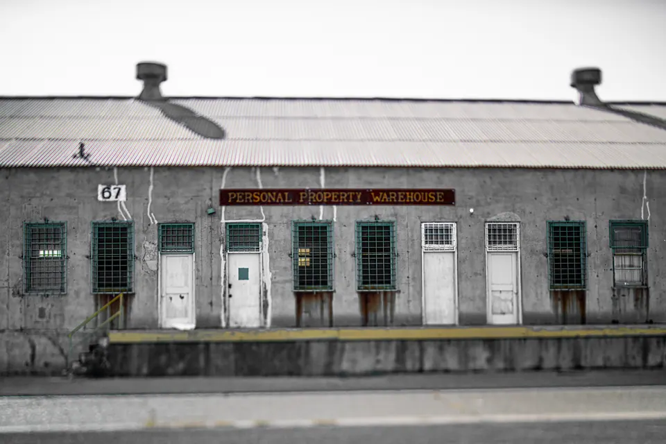 Pale doors and windows line the front of a weathered freight building.